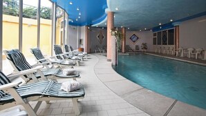 Ett område vid poolen med solstolar, en pool och utsikt över omgivningarna.