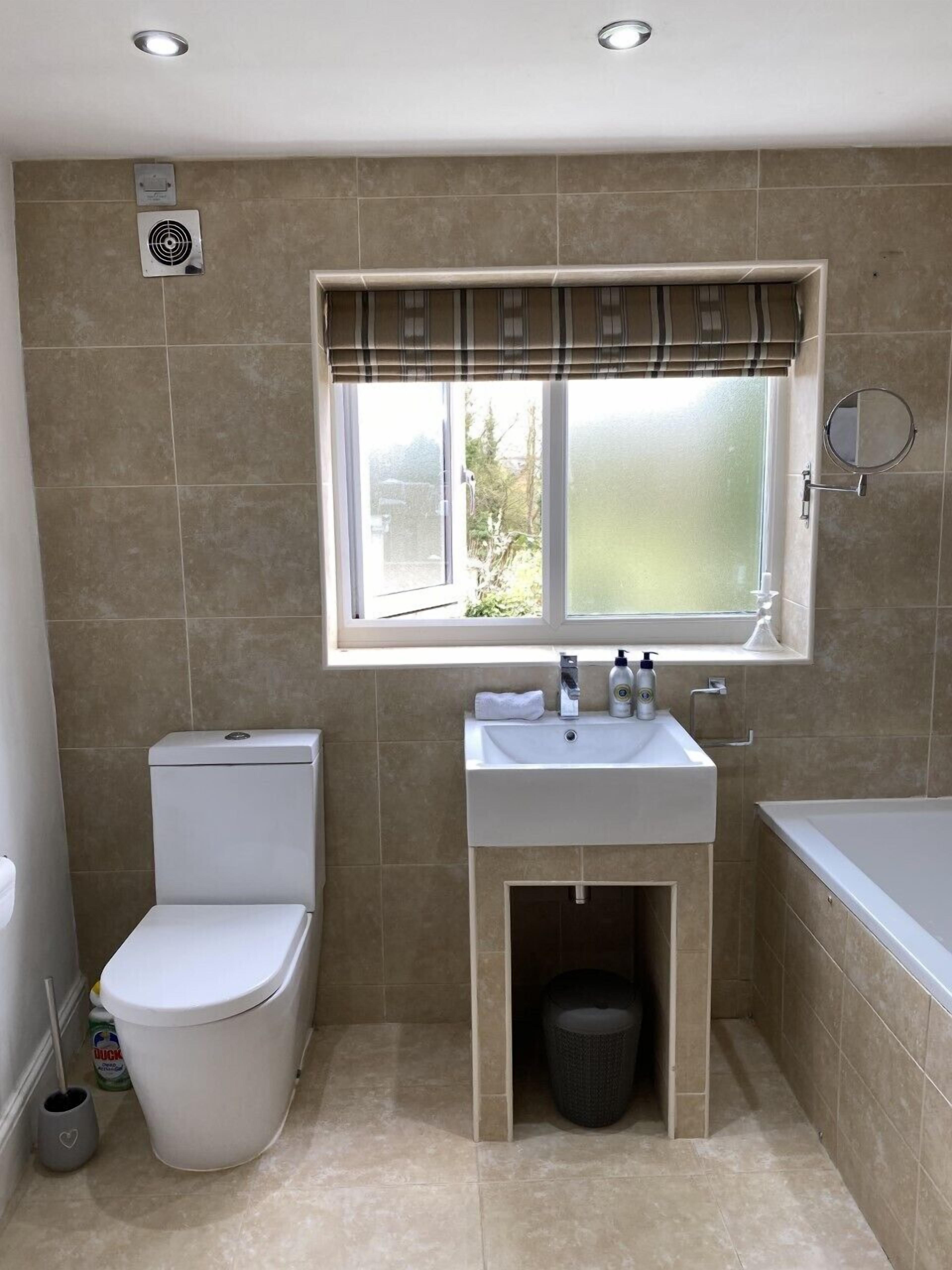A bathroom with a toilet, sink, and bathtub.