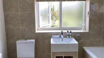 A bathroom with a toilet, sink, and bathtub.