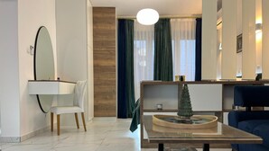 Ein modernes Wohnzimmer mit einem weißen Sessel, einem kleinen Tisch mit einem dekorativen Gegenstand, einem blauen Sofa und einer Holzwand.