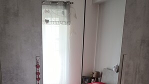 A bedroom with a red bed, a white towel, a mirror, and a wall with a heart decoration. - Holiday home in the Palazzo dei Normanni area and historic center. (Palermo)