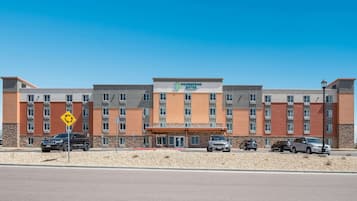 Un hotel de varios pisos con entrada central y un letrero que dice "Woodspring Suites".