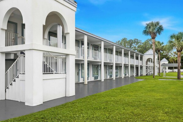A white building with multiple balconies and a covered walkway. - Suburban Studios Brunswick of I-95 (Brunswick)