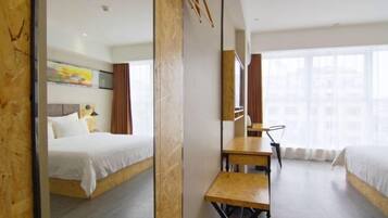 Habitación de hotel moderna con una cama grande, un escritorio y una ventana con vistas a la ciudad.