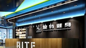 A modern fitness center with a prominent reception desk labeled "AITE." - Meet Fashion Hotel (Huidong OCT Store) (Huidong)