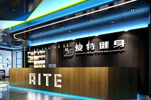 A modern fitness center with a prominent reception desk labeled "AITE."