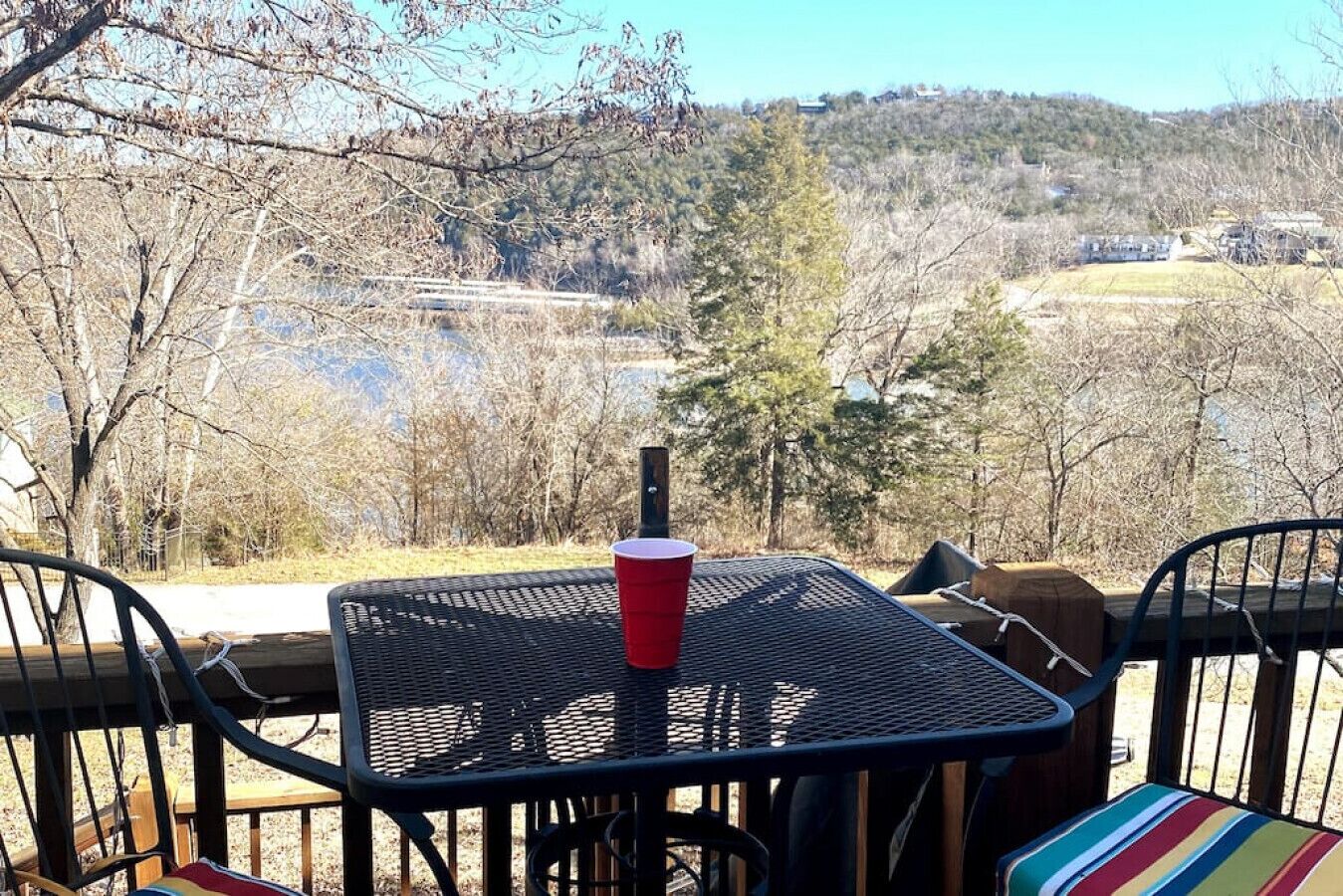 A patio with a table and chairs overlooking a scenic landscape.