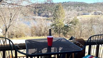 A patio with a table and chairs overlooking a scenic landscape.