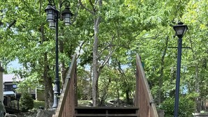 Eine Holztreppe mit Metallgeländern, die zu einer Betonpodestfläche führt.