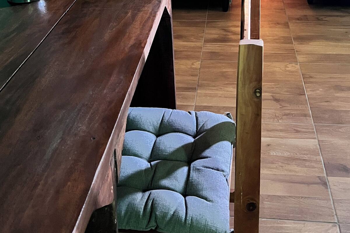 A hotel room with two beds, a wooden table, and a chair.