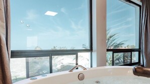 A hot tub with a clear view of the sky and palm trees outside. - Peixe Gordo Hotel (Icapuí)
