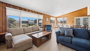A modern living room with a sofa, armchair, and coffee table. - Cair Paravel | 680 ft to the beach | (Virginia Beach)