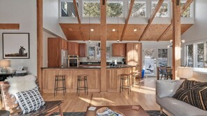 A modern kitchen with wooden cabinets, a central island, and bar stools. - Durango Mountain House with Hot Tub and Views - great location (Durango)