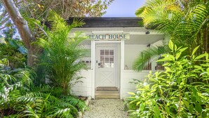 A white building labeled "BEACH HOUSE" with a gravel path leading to the entrance. - ***NEW*** Beautiful Cottage Canal Front&Boat Dock (Sanibel)