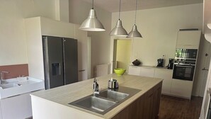 A modern kitchen with a central island, stainless steel appliances, and pendant lighting. - Large vacation home in the Lot in the heart of the Quercy regional park (Saint-Sulpice)