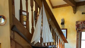 A wooden staircase with a sailboat model hanging from the balustrade, a lantern on the wall, and a patterned bench at the bottom. - Redfish Lodge- Steinhatchee Landing Resort Sleep 5 (Steinhatchee)