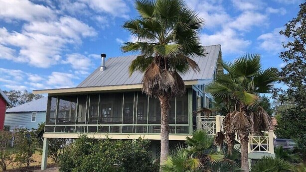A two-story house with a metal roof, large windows, and a porch. - Redfish Lodge- Steinhatchee Landing Resort Sleep 5 (Steinhatchee)