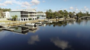 A waterfront property with a large building featuring multiple balconies and a dock with boats. - Redfish Lodge- Steinhatchee Landing Resort Sleep 5 (Steinhatchee)