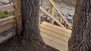 A wooden staircase leading to a beach with a view of the water and a sunset. - WATERFRONT Maine Historical Cottage with Separate Guest Cottage (Northport)