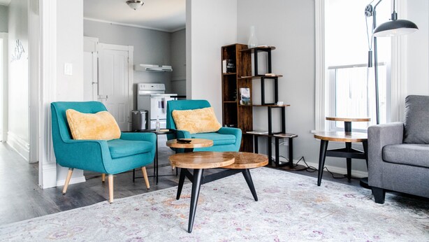 A modern living room with teal and gray sofas, a wooden coffee table, and a bookshelf. - Blocks from River & DT Missoula! University apt now offering mid-term rentals! (Missoula)