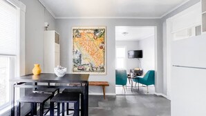 A modern kitchen with a dining area, a large map artwork on the wall, and a TV mounted on the wall. - Blocks from River & DT Missoula! University apt now offering mid-term rentals! (Missoula)