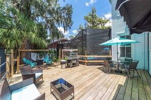 A wooden deck with outdoor furniture, a grill, and a pool. - Private historic district apt with pool-suite A (Ocala)