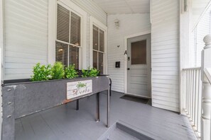 A porch with a planter box labeled 'Herbs' and a door marked with the letter 'A'. - Private historic district apt with pool-suite A (Ocala)