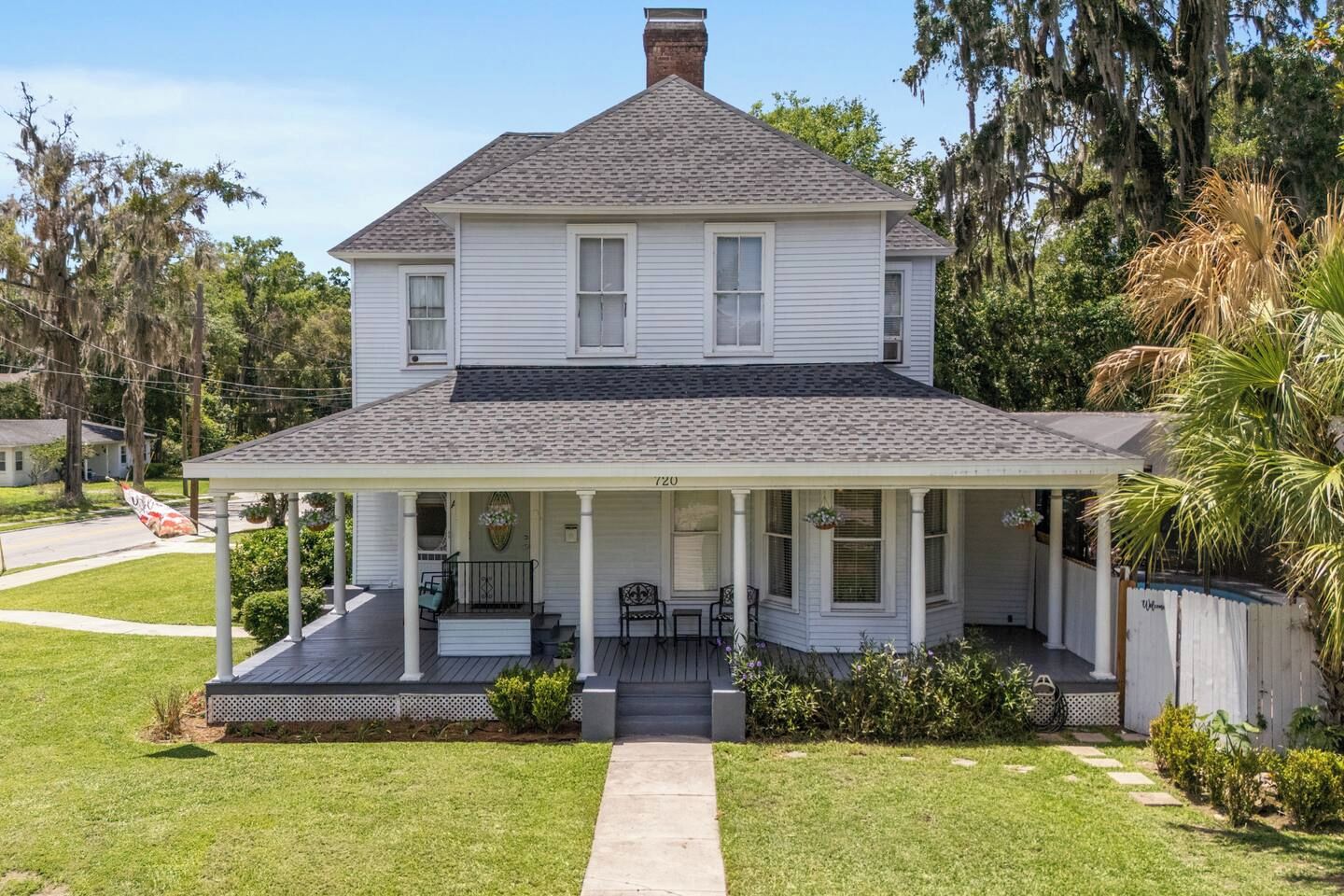A two-story house with a covered porch and a front yard.