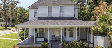 A two-story house with a covered porch and a front yard.