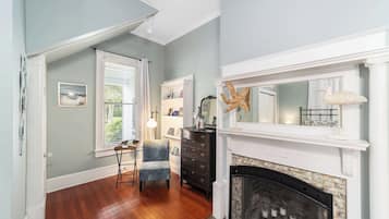 A room with a fireplace, a bookshelf, a desk, and a chair.
