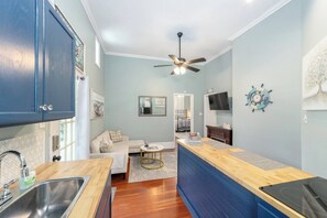 A compact kitchen with a wooden countertop, a built-in stove, and a ceiling fan.