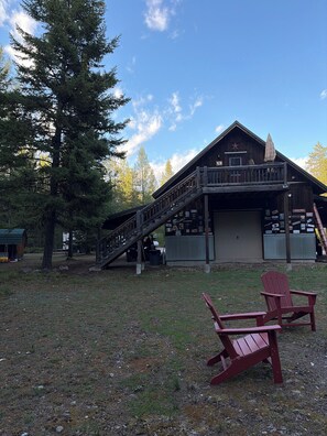 A wooden building with a balcony, a staircase, and a sign for a log cabin.