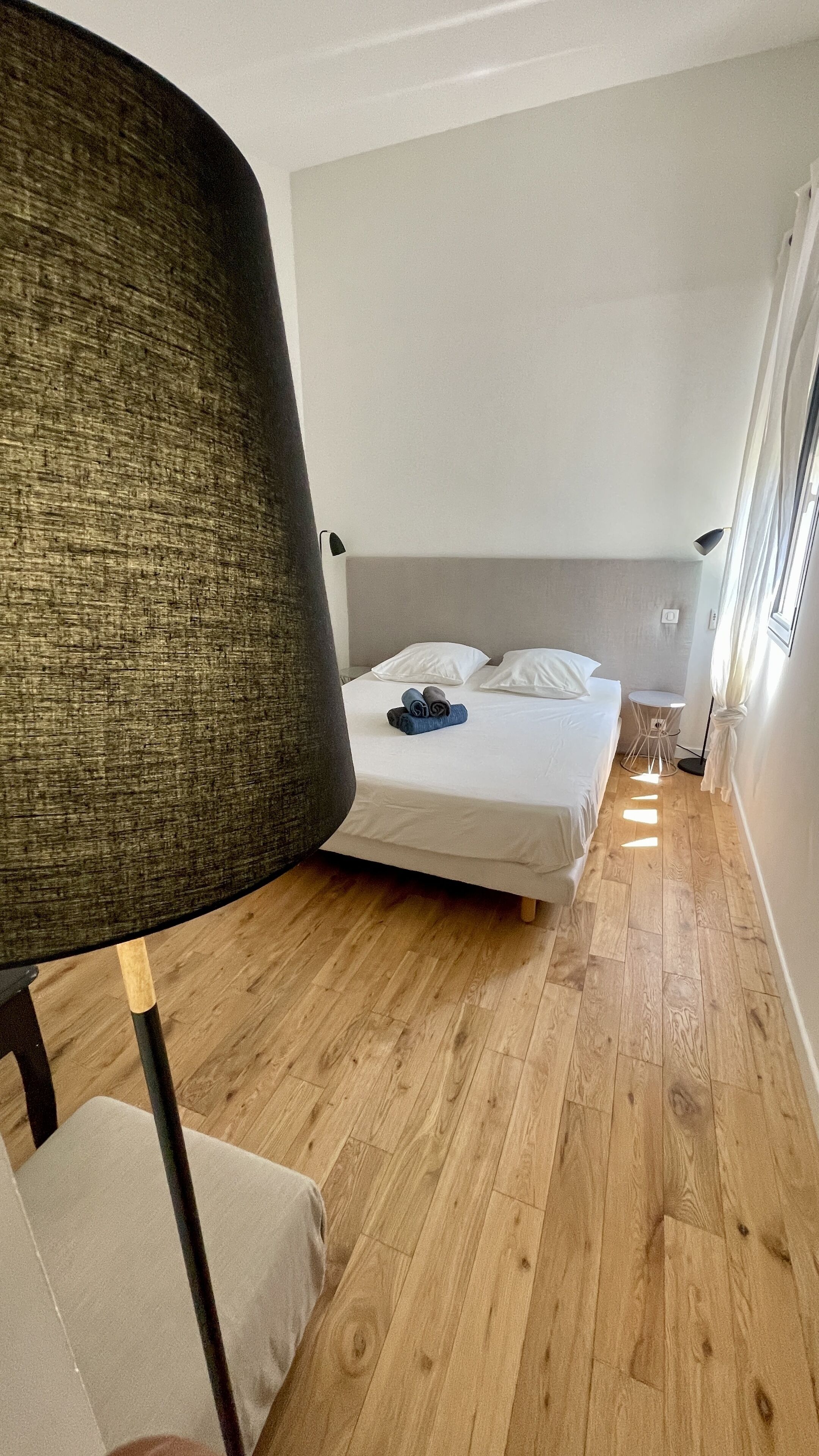 Un dormitorio con una cama, una silla y una mesita.