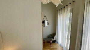 Ein Hotelzimmer mit einem großen Bett, einem runden Tisch, einem Stuhl und einem Spiegel an der Wand.