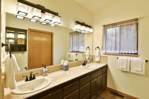 A bathroom with two sinks, a large mirror, and a window with sheer curtains. - Timber Height's, Classy home in the pines. (Dunsmuir)