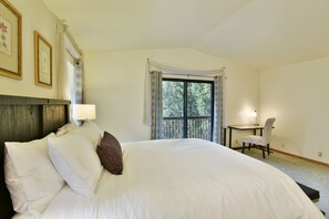 A bedroom with a large bed, a desk, and a chair. - Timber Height's, Classy home in the pines. (Dunsmuir)