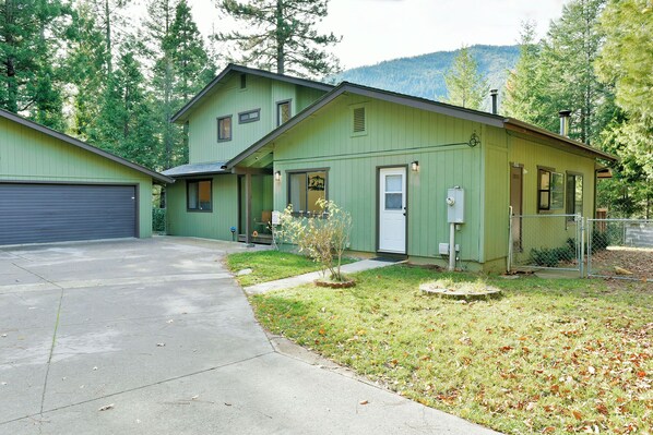 A two-story house with a green exterior, a front porch, and a garage. - Timber Height's, Classy home in the pines. (Dunsmuir)