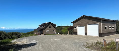 A two-story house with a garage, a covered porch, and a view of the ocean.