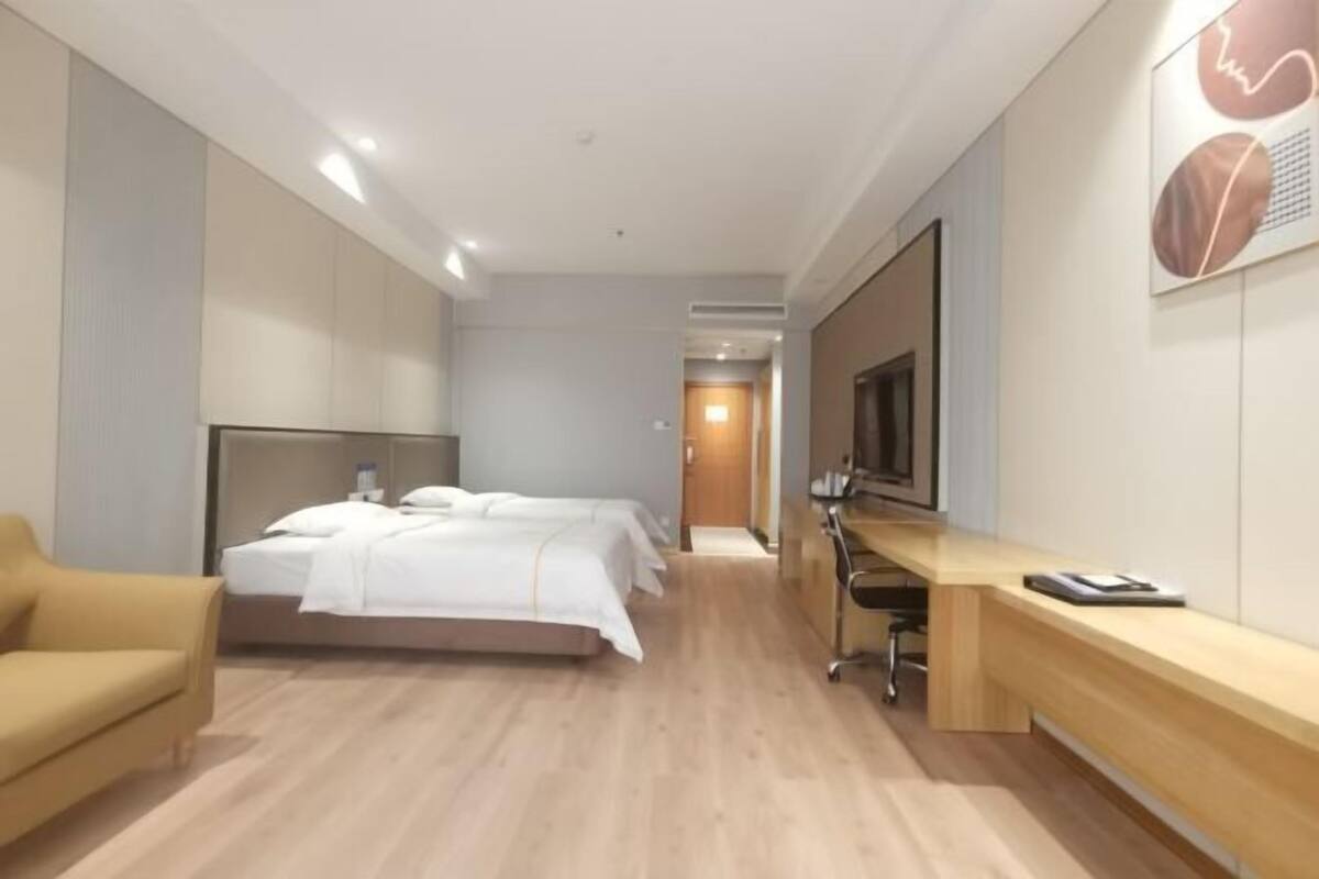 Une chambre d’hôtel avec un lit, un bureau, une chaise et un téléviseur.