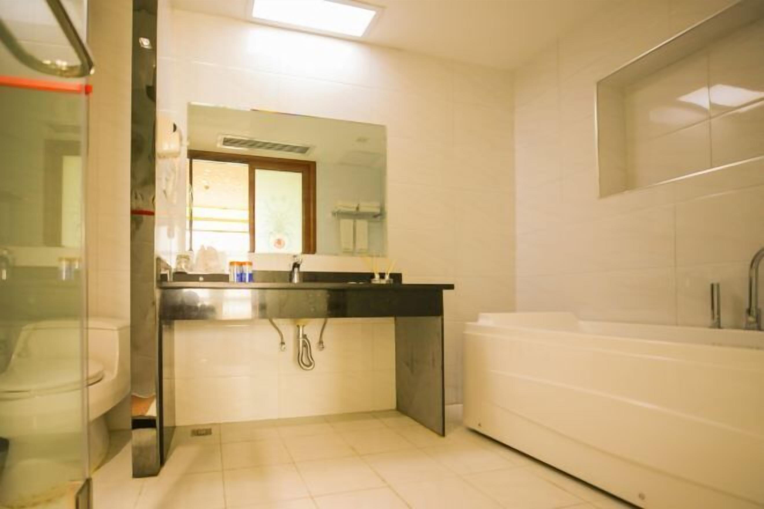 A modern bathroom with a toilet, sink, and bathtub.