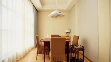 A dining area with a table, chairs, a lamp, and a ceiling fan.