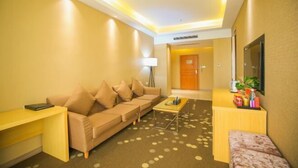 A hotel lobby with a sofa, a desk, a coffee table, and a reception area. - Meicheng Huatian Holiday Hotel (Anhua)