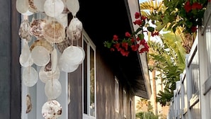 A narrow corridor with a decorative hanging light fixture and a white gate at the end. - Modern Beach Bungalow, walk to beach, family and dog friendly (Oxnard)