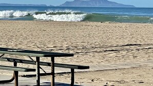 A beach with a wooden picnic table and a view of the ocean and distant mountains. - Modern Beach Bungalow, walk to beach, family and dog friendly (Oxnard)