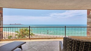 A balcony with a view of the sea, featuring a wicker chair and a bench. - RPB Property Management (Puerto Peñasco)