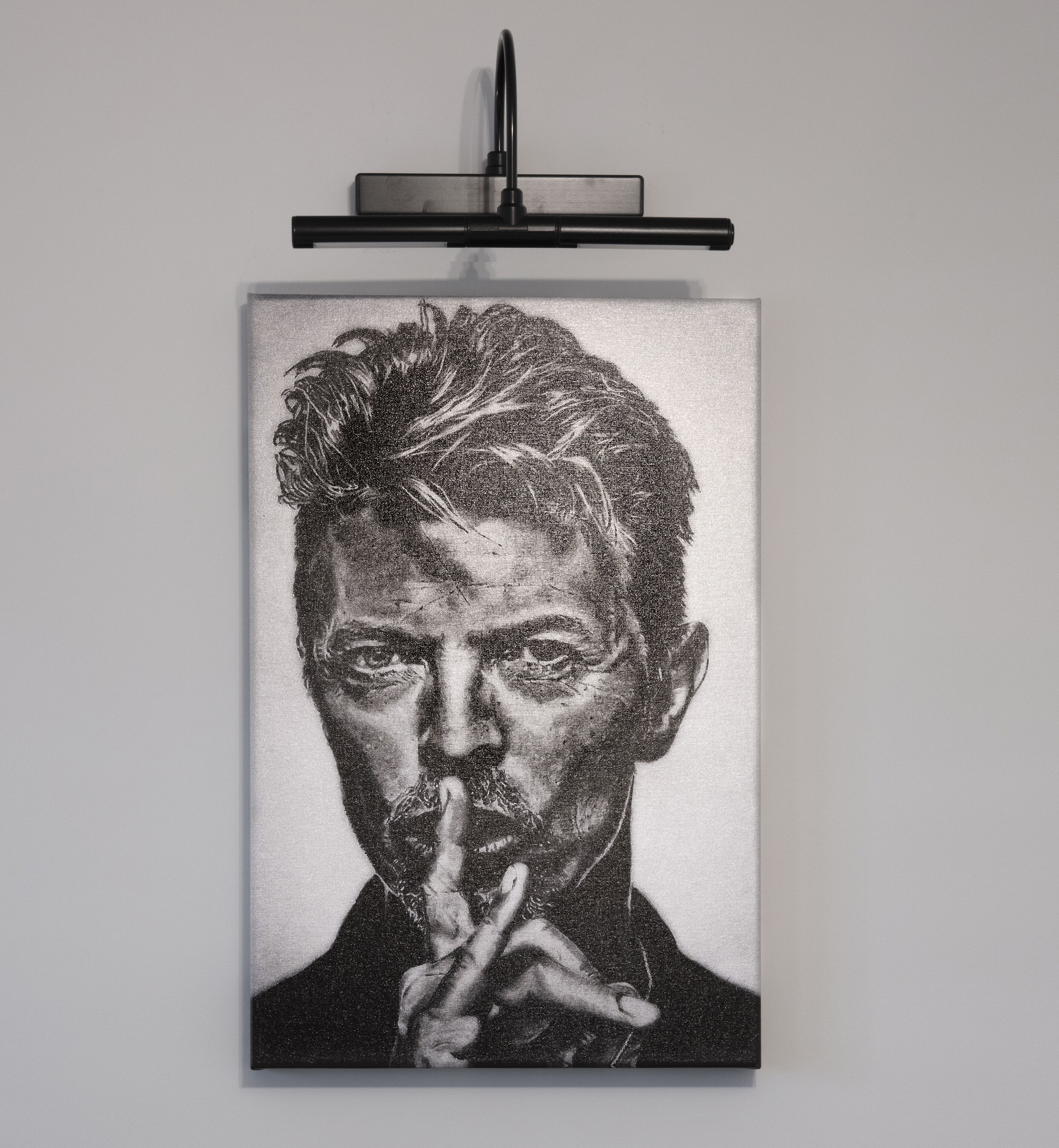 Ein gerahmtes Schwarz-Weiß-Porträt einer Person mit einem Mikrofon, das an einer Wand angebracht ist.