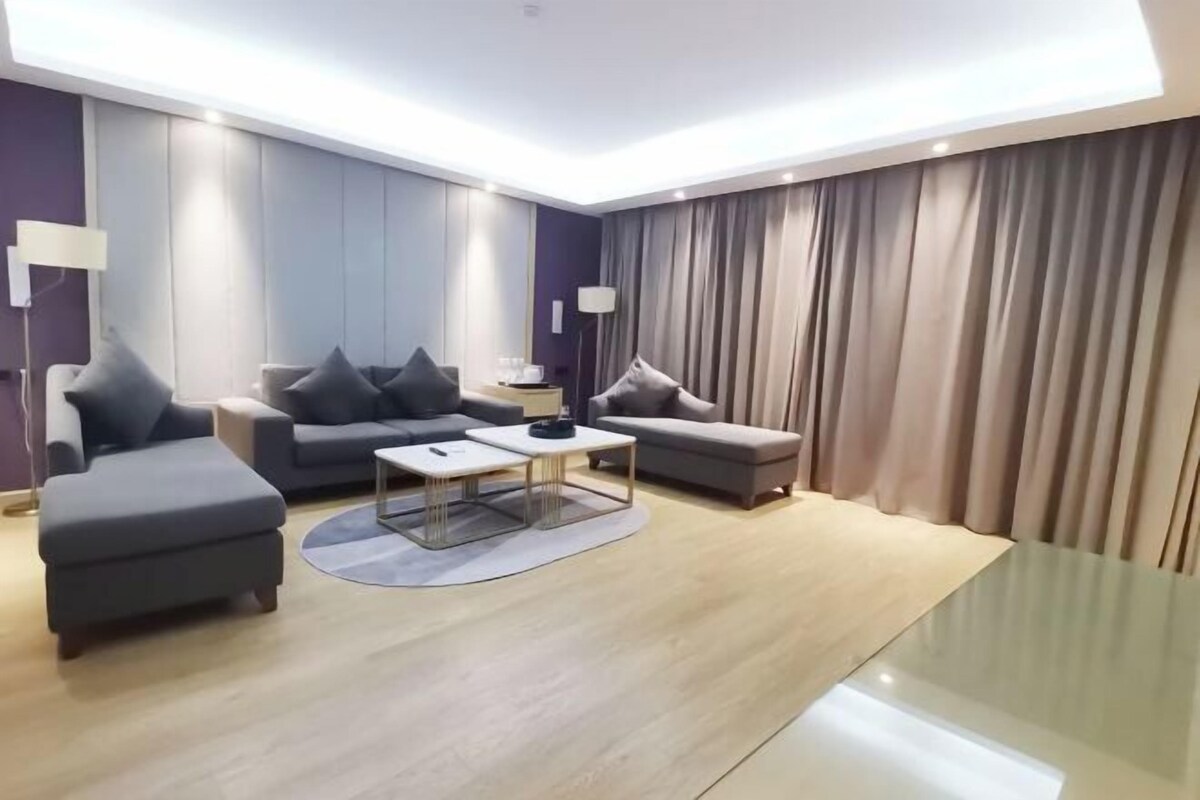 Uma sala de estar moderna com um conjunto de sofá, uma mesa de centro e uma luminária.
