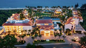 A resort with multiple buildings, a swimming pool, and a view of the ocean. - Radisson Resort Phan Thiet (Tien Thanh)