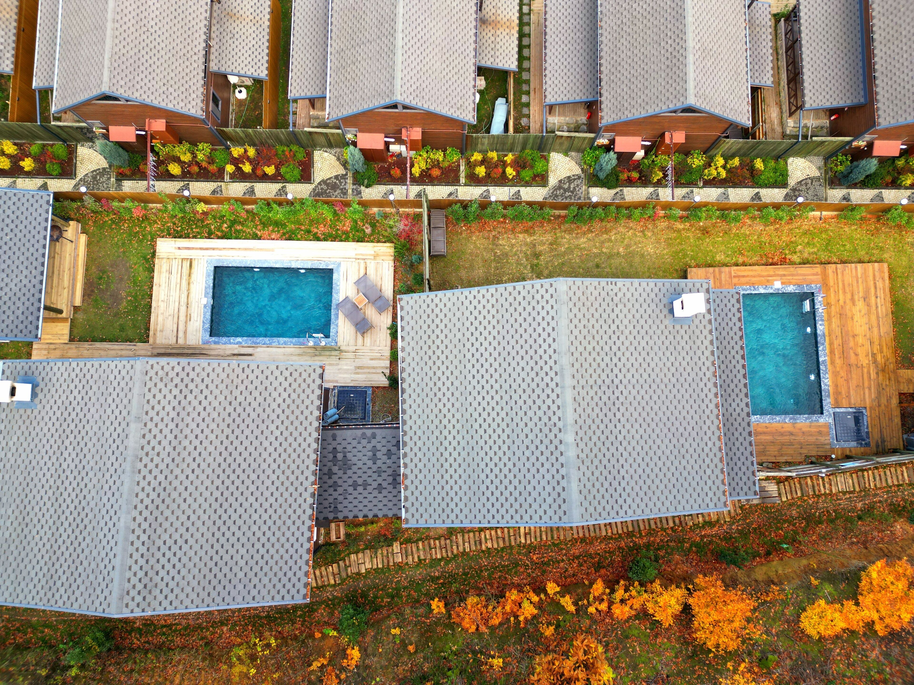 Ein modernes Hotel mit mehreren Einheiten, Außenpools, Gartenanlagen und einer Dachterrasse.