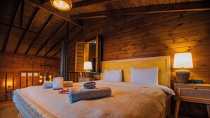 A wooden cabin-style bedroom with a large bed, two bedside lamps, and a wooden headboard. - Woodlodge Country Sapanca (Sapanca)